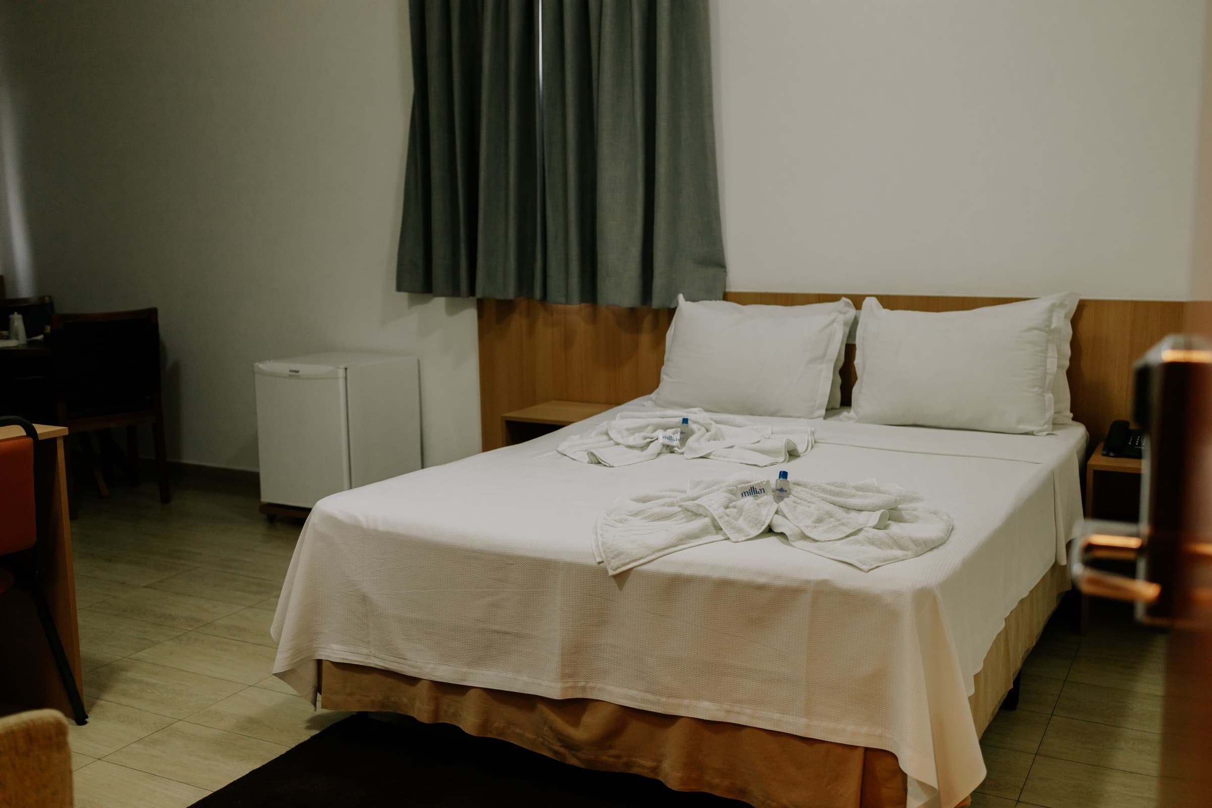 Cama de casal queen da Suíte, com toalhas decorativas